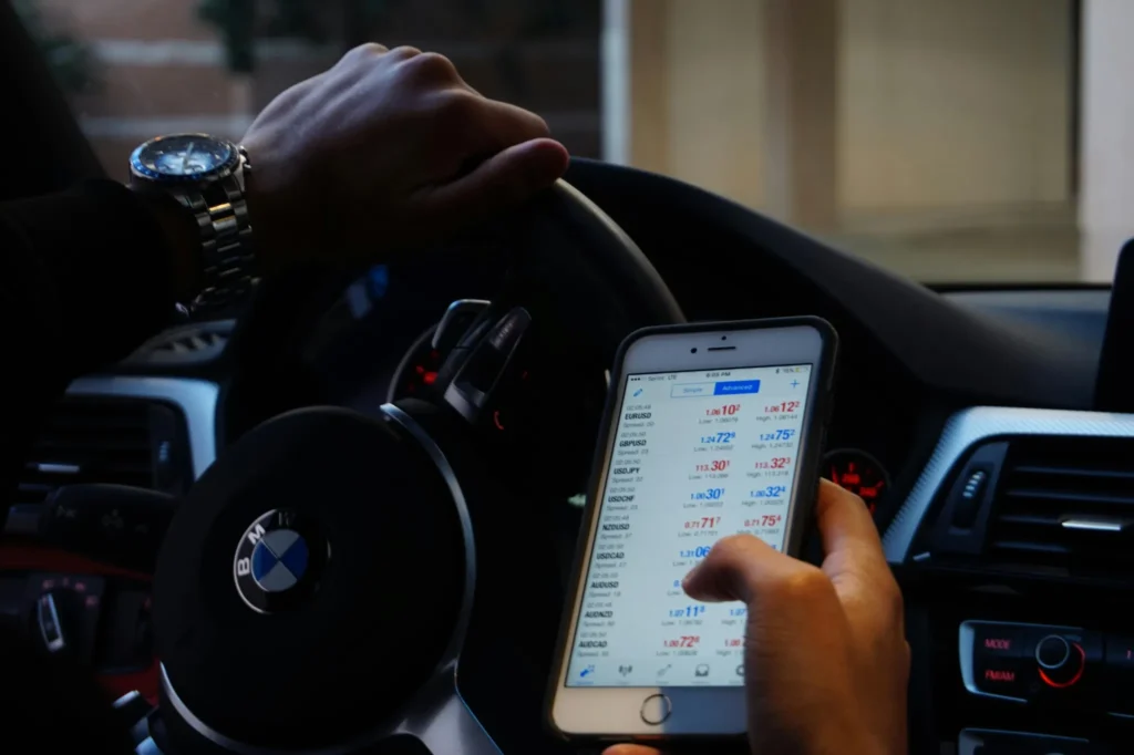 Trader überprüft Forex-Kurse auf dem Smartphone unterwegs mit einem mobilen Trading-System.