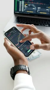 Trader analysiert Kryptowährungen auf Smartphone mit integriertem Trading-System.